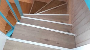A wooden spiral staircase with white trim and blue accents.