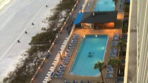 An aerial view of a hotel with multiple swimming pools, sun loungers, and a small circular pool.