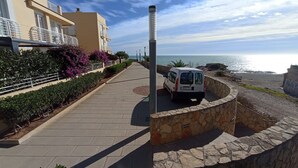 Un camino empedrado con un muro de piedra y una furgoneta estacionada.