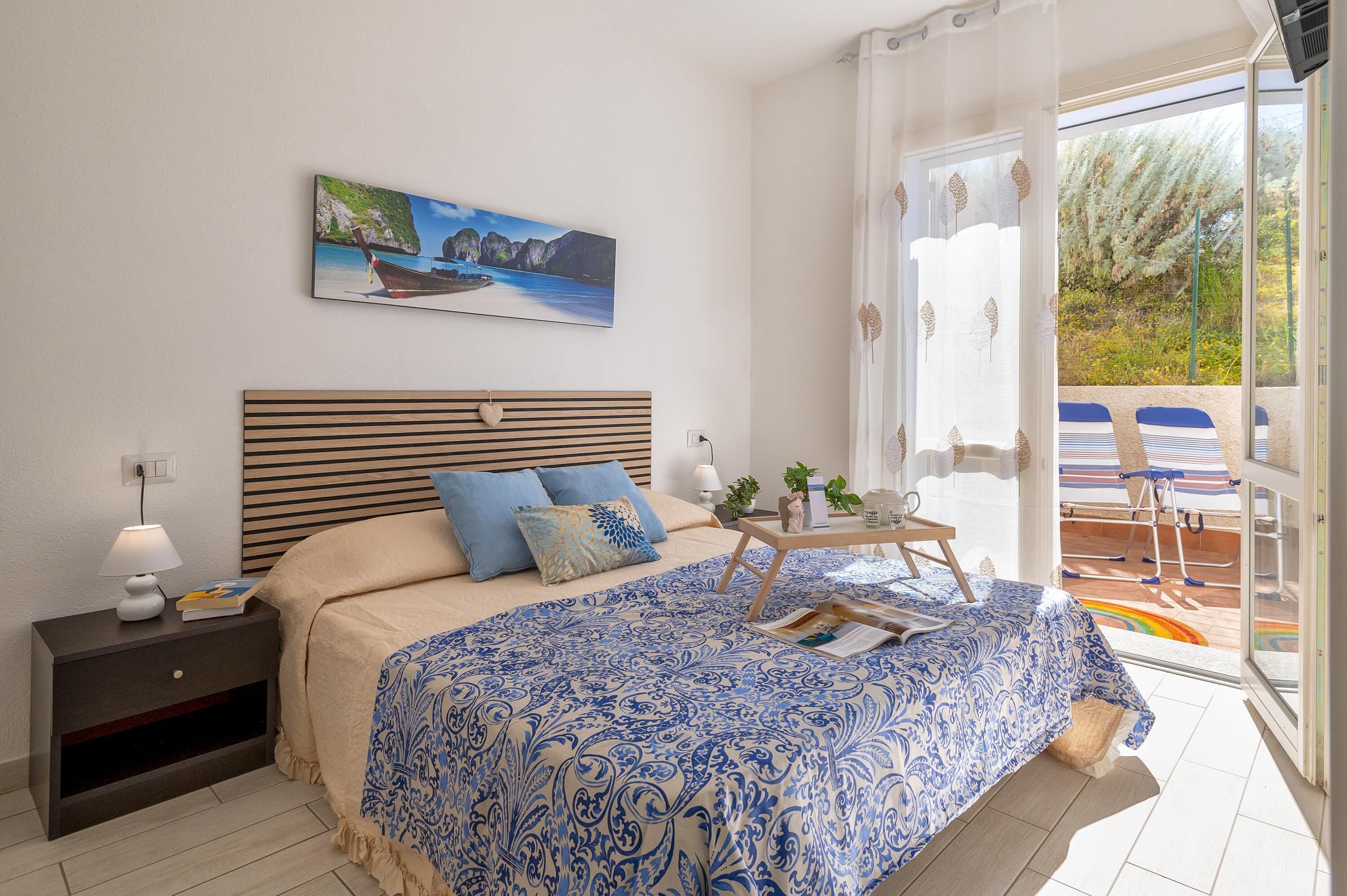 Un dormitorio con cama, mesita de noche y vistas al exterior.