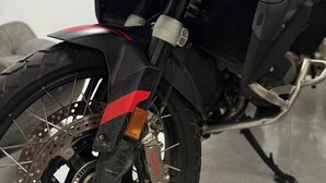 En motorcykel med ett tydligt vindskydd, röda detaljer och en logotyp med varumärket på sidan.