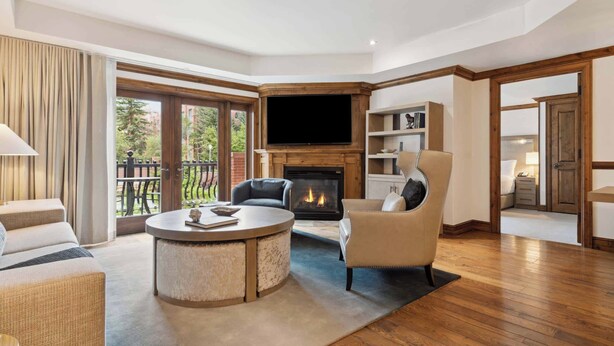 A spacious living room with a fireplace, comfortable seating, and a large TV. - The Aspen Mountain Residences 22AB - 2 Bedroom Residence (Aspen)