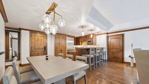 A spacious kitchen with wooden cabinets, a central island, and modern lighting fixtures. - The Aspen Mountain Residences 22AB - 2 Bedroom Residence (Aspen)