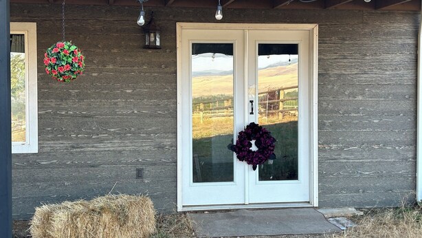 A wooden house with a double door, two hanging light fixtures, and two wreaths on the door. - Beautiful mountain views, Close to trails, Pet friendly Farm Awaits you! (Florence)