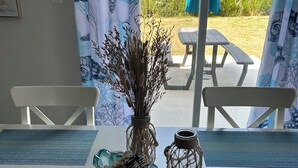 A dining table with blue placemats, a vase with dried plants, and a decorative bowl with beads. - Large, beautiful house! 1.5 miles to Bethany Beach! Resort style amenities!!! (Ocean View)