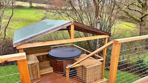 A wooden deck with a hot tub and a small wooden structure with a roof. - Ashdown Luxury Dome (Hoath)