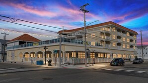 Un hôtel à plusieurs étages doté d’un balcon, d’une galerie couverte et donnant sur la rue.