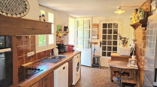 Una cocina compacta con lavavajillas, pileta y un pequeño comedor.