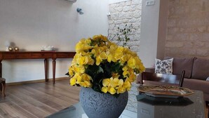 Una sala de estar con una mesa de centro de vidrio, una pared de piedra y un banco de madera.