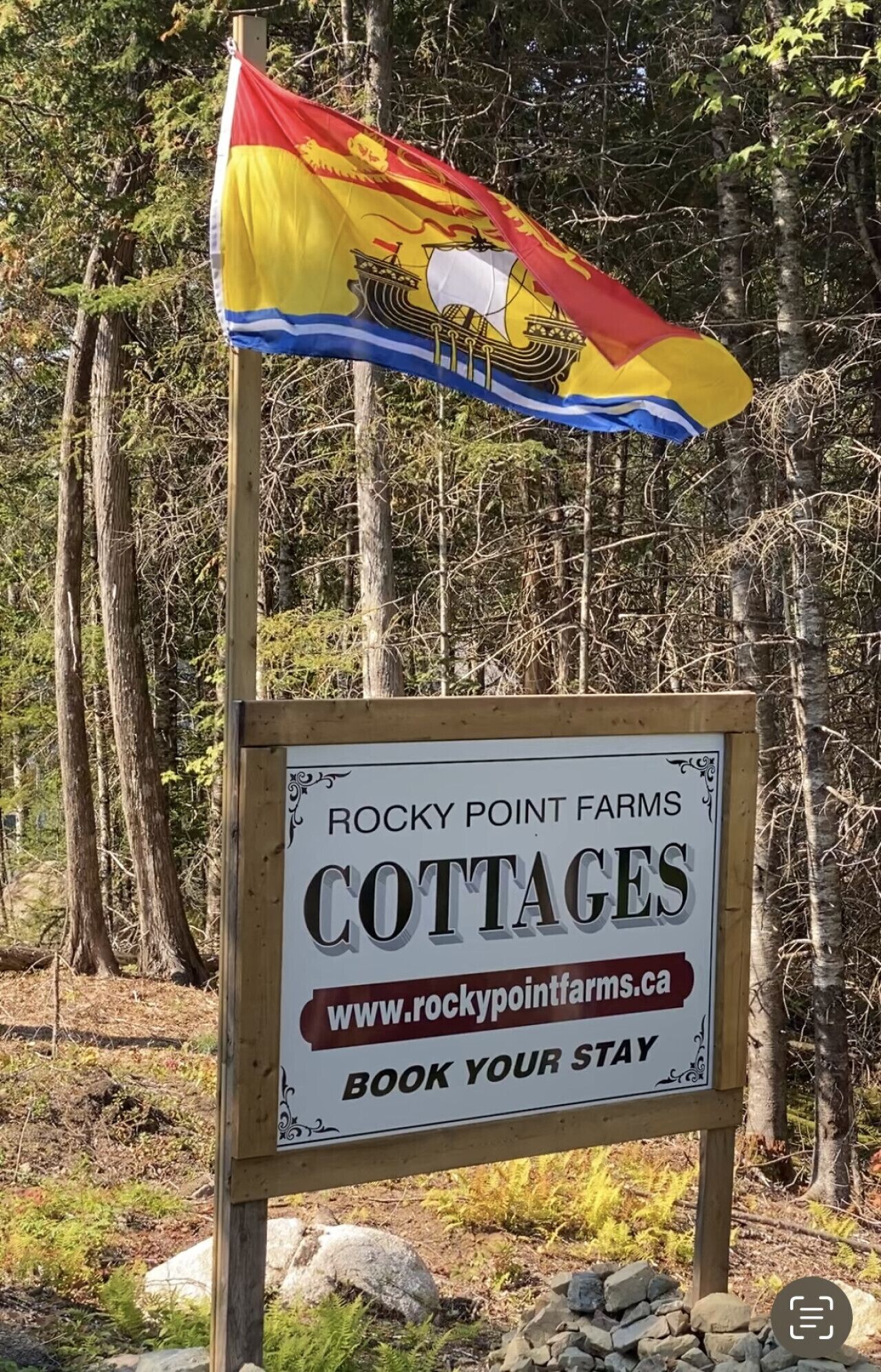 Segnaletica per Rocky Point Farms Cottages, con sito web e invito a prenotare un soggiorno.