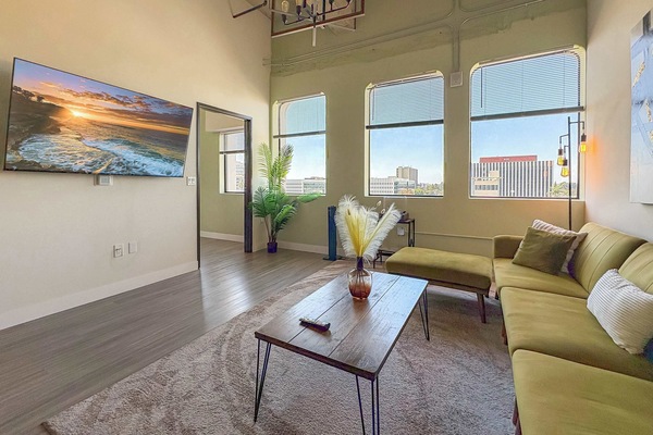 Living room with a sofa, Full-size air mattress, and a 65" Smart TV (Netflix, Hulu, and Disney+, we logged them remotely) included for free.