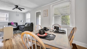 A dining area with a table set for two, a ceiling fan, and a view of the outdoors through the window. - Quaint 1 Bedroom House on N Martin Luther King Jr Blvd, Lansing: Your Ideal Home (Lansing)