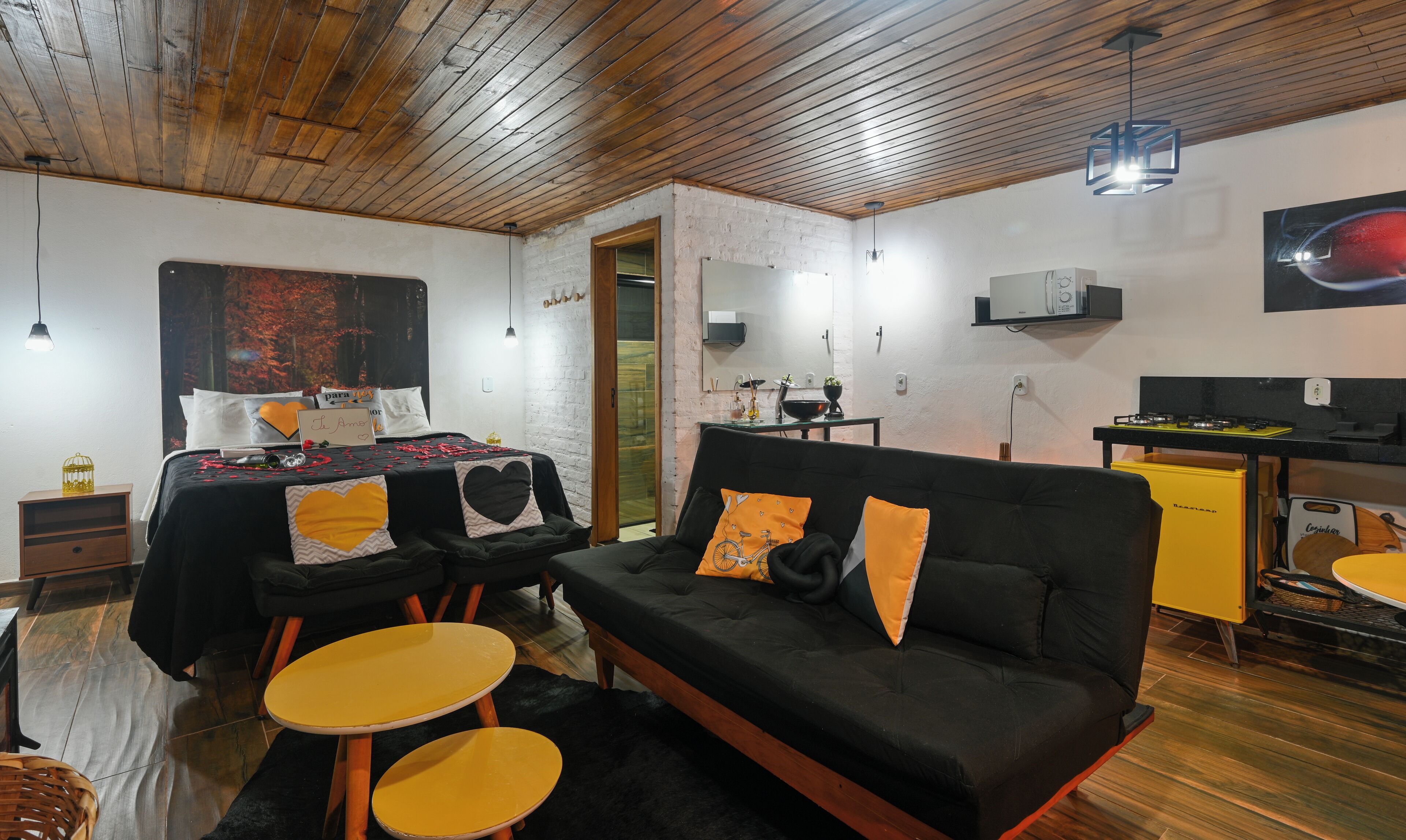 A cozy room with a bed, a sofa, and a dining area.