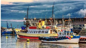 A harbor with several boats docked, a large building with a sign reading "VENTURE SEAFOODS," and a cloudy sky. - 1 Bed Studio Sleeps 4 - Seaside, Dog Friendly (Bridlington)