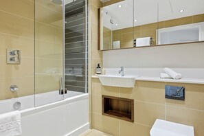 A modern bathroom with a glass-enclosed shower, a white sink, and a mirror above the sink. - Stunning 1-bed Apartment in London (London)