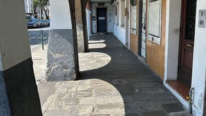 A corridor with stone flooring, a door at the end, and a building with a white facade and a wooden door on the right. - 3 bedroom apartment in venice (Venezia)