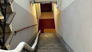 A staircase with a handrail, a red carpet, and a door at the top. - 3 bedroom apartment in venice (Venezia)