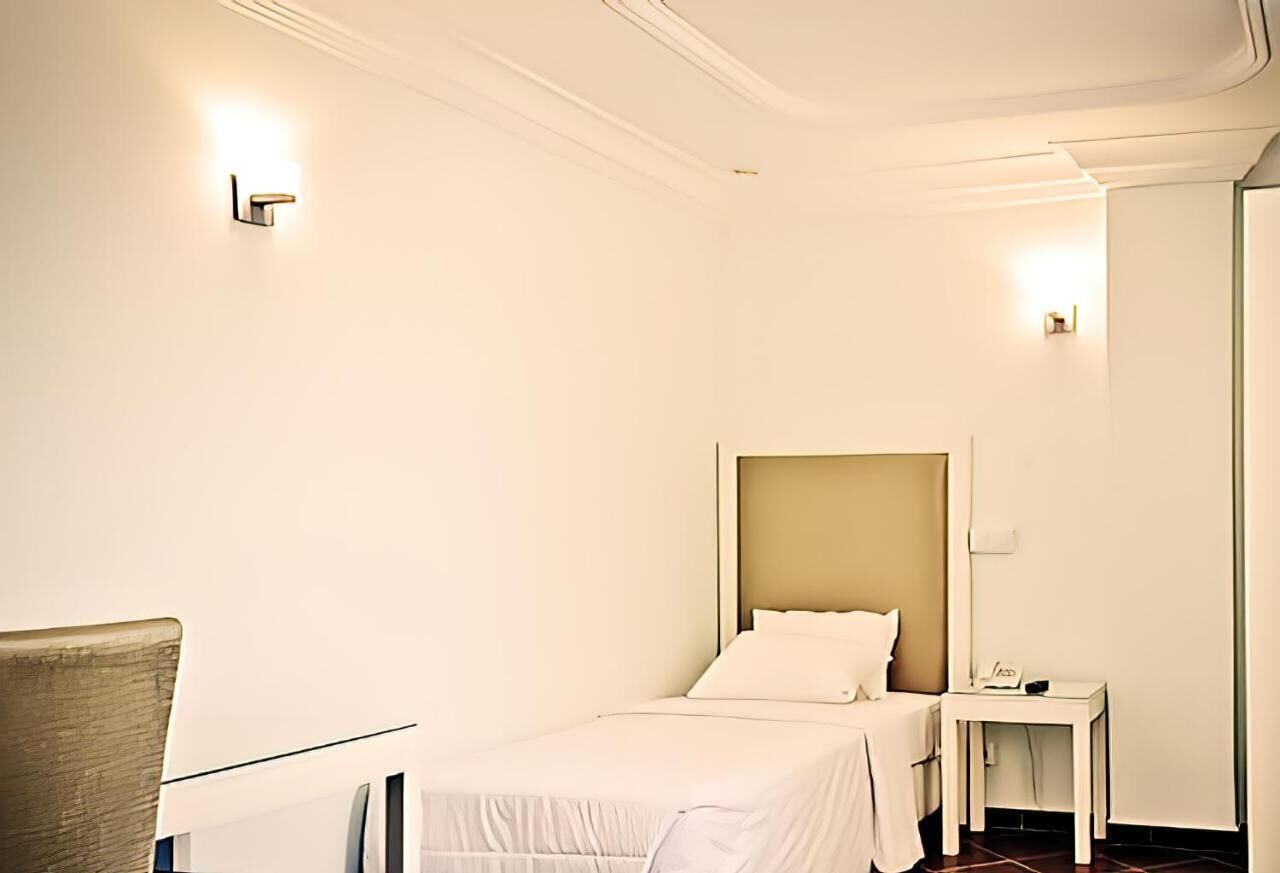 Une chambre d’hôtel avec un lit, une table de chevet et une chaise.
