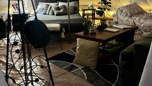 A tented accommodation with a bed, a table, a chair, and a hanging light fixture. - Stunning 1-bed Glamping Tent in Cleveland (Conroe)