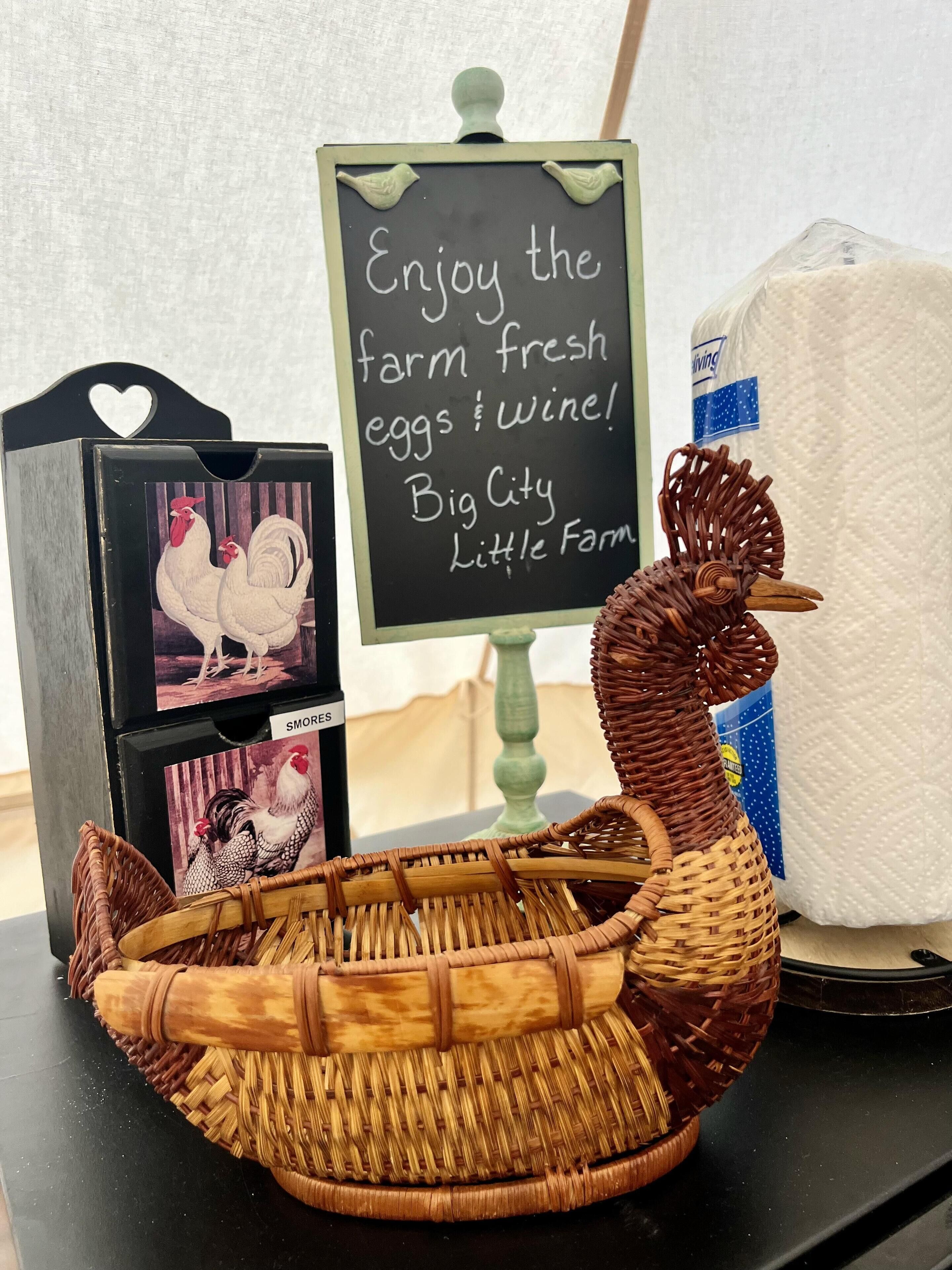 A wicker basket, a chalkboard sign, and a blackboard with images of chickens.