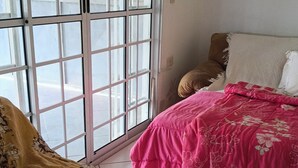 A room with a bed, a window with a view, and a door. - Green slice (Mairinque)