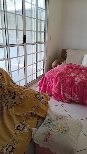 Ein Zimmer mit einem Bett, einem Fenster mit Blick und einer Tür.
