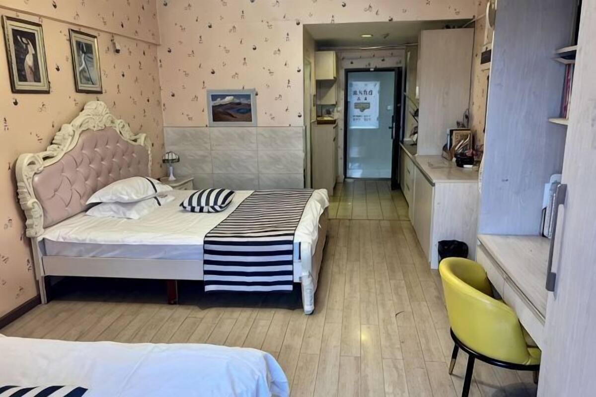 A bedroom with a bed, bedside table, and a chair.