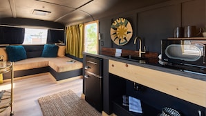 A compact kitchen with a microwave, sink, and wooden countertop. - Acres Landing (Desert Hot Springs)