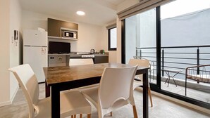 Une cuisine moderne avec un coin repas, un balcon offrant une vue agréable et un réfrigérateur.