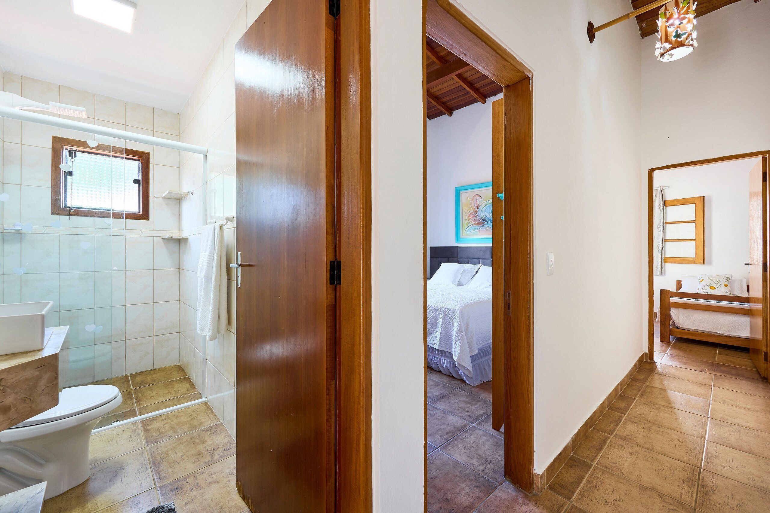 Casa de banho com sanita, lavatório e zona de duche.