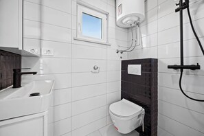 Regadera, secadora de cabello, toallas, papel de baño 