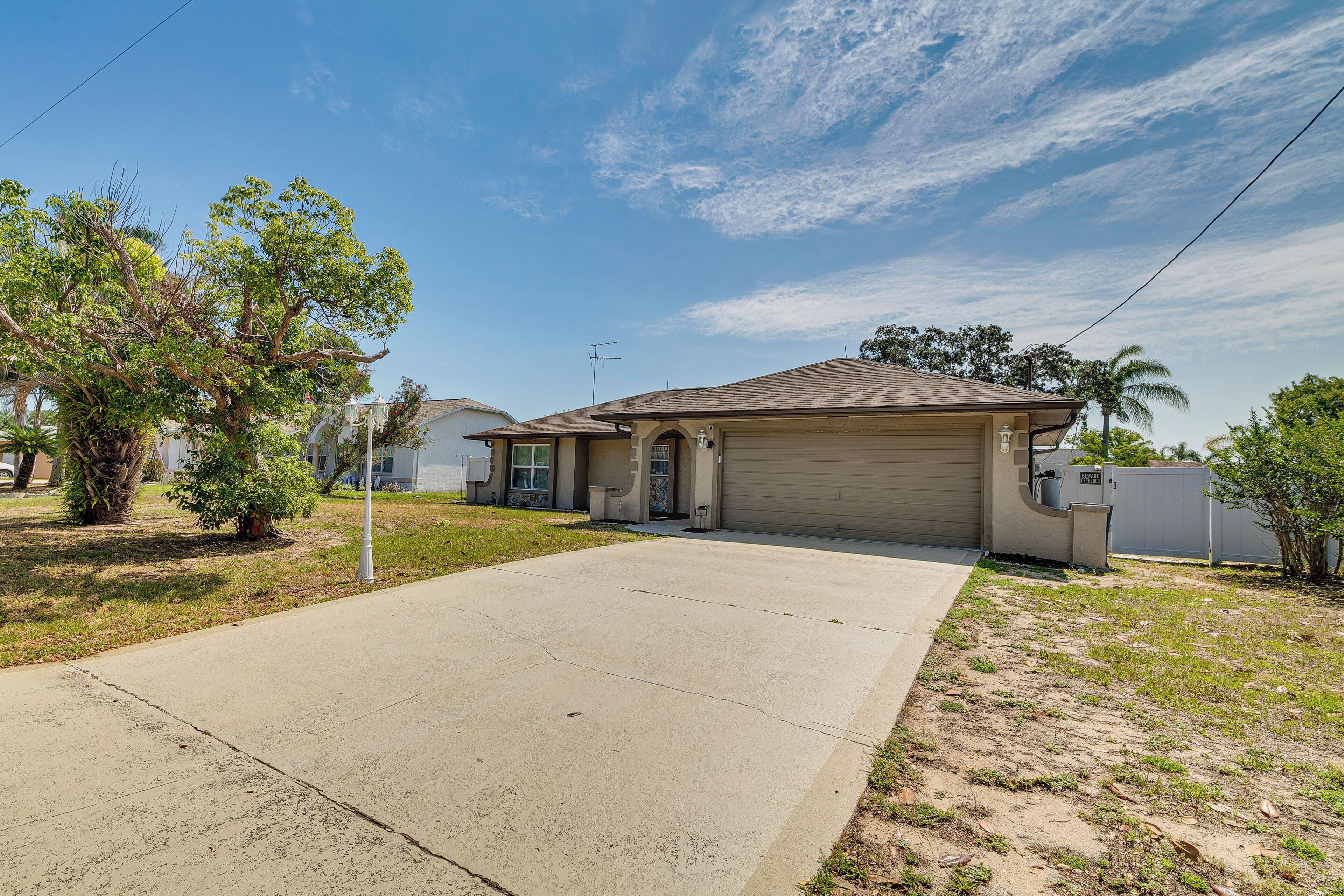 A residential house with a garage, a driveway, and a lawn.