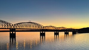 Un puente con múltiples arcos sobre aguas tranquilas, reflejando el cielo.