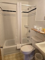 Bañera con ducha, toallas, jabón, shampoo