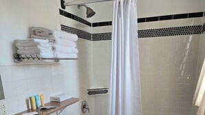 Un baño con inodoro, lavabo, bañera y cortina de ducha.