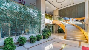 A modern interior with a glass wall, a spiral staircase, and potted plants. - Four Points by Sheraton (Beijing Branch) (Beijing)