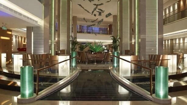 A hotel lobby with a central staircase, seating area, and a reception desk. - Four Points by Sheraton (Beijing Branch) (Beijing)