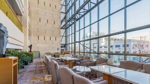 A modern indoor space with a long table and chairs, large windows, and a patterned floor. - Four Points by Sheraton (Beijing Branch) (Beijing)