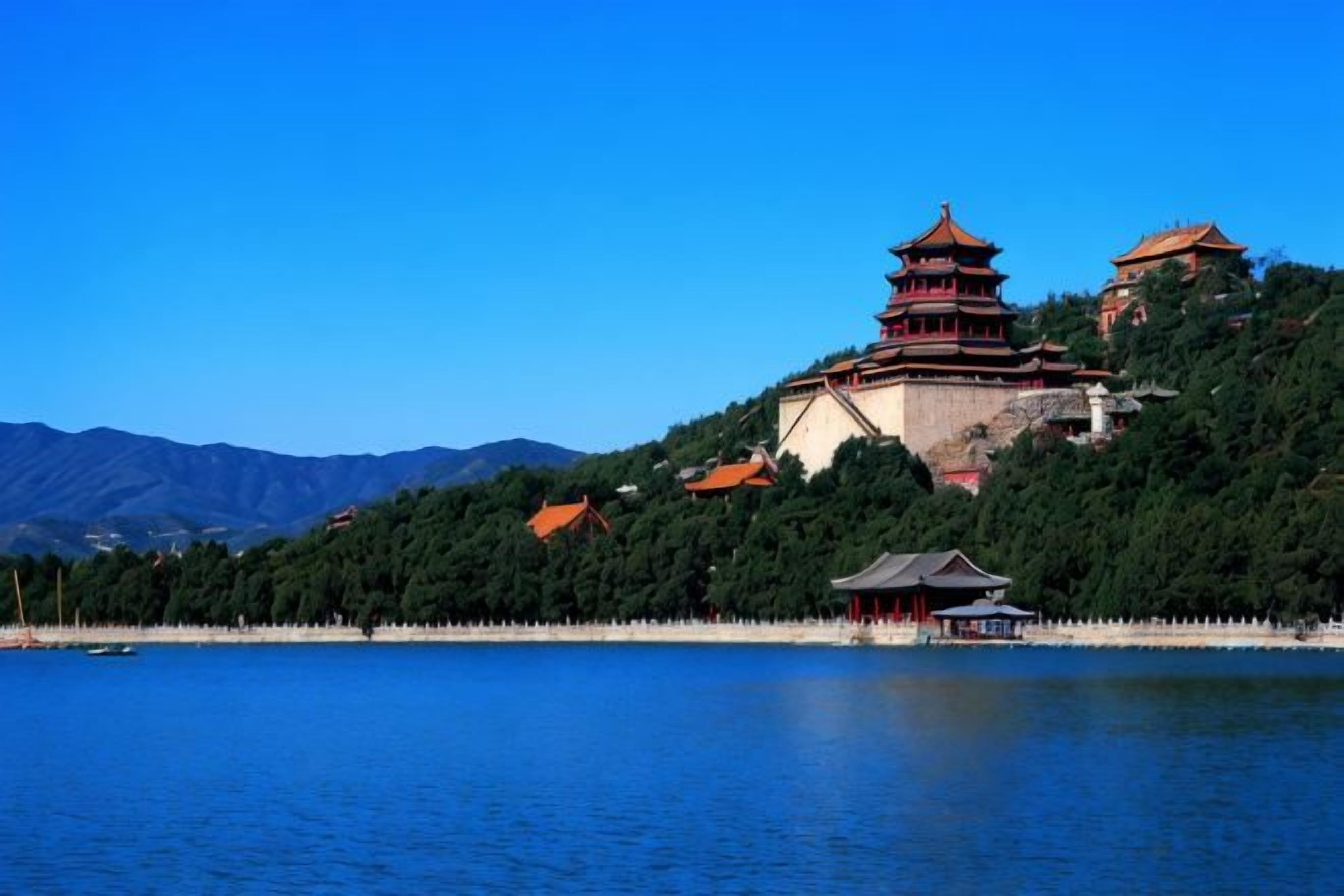 Une pagode chinoise traditionnelle, perchée sur une colline et dominant un lac paisible, avec des montagnes en arrière-plan.