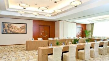 A conference room with a long table, multiple chairs, and a large mirror.