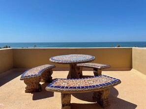 A round table with mosaic tile seating on a balcony overlooking the sea. - Corona del Mar by Rocky Host (Puerto Peñasco)