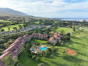 A resort with multiple buildings, a golf course, and a swimming pool.