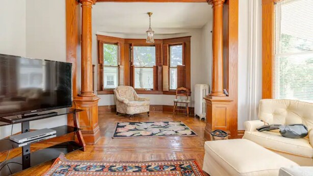 A living room with a television, a sofa, a chair, and a patterned rug. - The Carew House Sleeps 10 Fenced 4BR Full Kitchen Steps2 YCP (York)