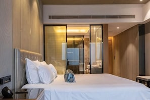 Ein Hotelzimmer mit Bett, Nachttisch und einem großen Spiegel.
