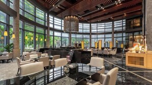 Eine geräumige Lobby mit hohen Decken, großen Fenstern und einer modernen Kristallleuchtre.'