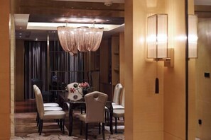 A dining area with a chandelier, a table with chairs, and a vase with flowers. - Beishan Hotel (Nantong)