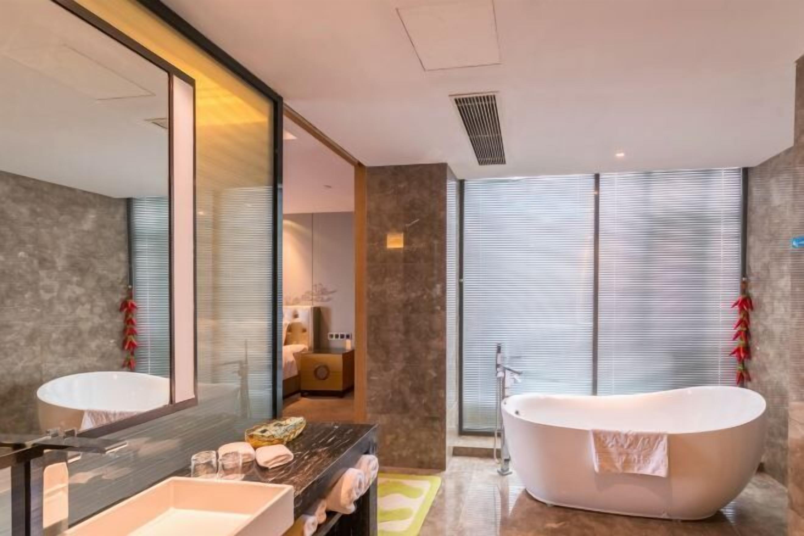A modern bathroom with a freestanding bathtub, a large mirror, and a vanity with a sink.