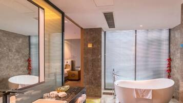 A modern bathroom with a freestanding bathtub, a large mirror, and a vanity with a sink.