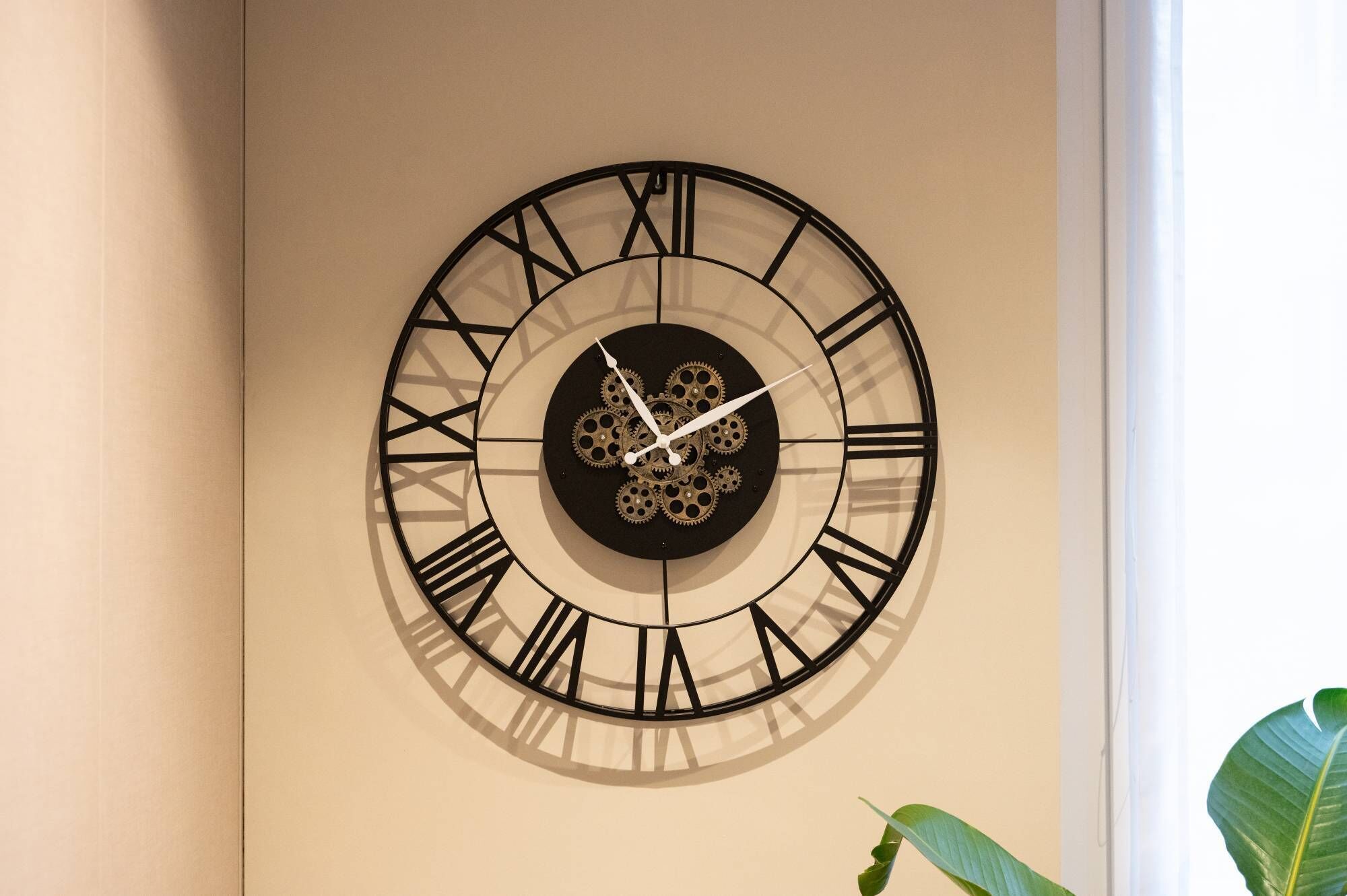Eine Wanduhr mit römischen Ziffern und Zahnrädern.