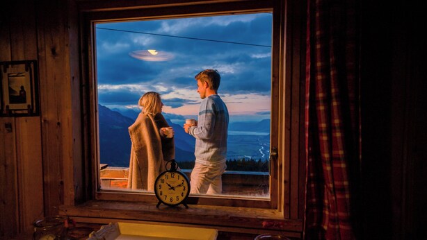 A room with a large window overlooking a mountainous landscape at dusk. - Mazot Douillet de Montagne Isolé en Pleine Nature en Autonomie D'énergie (Les Giettes)